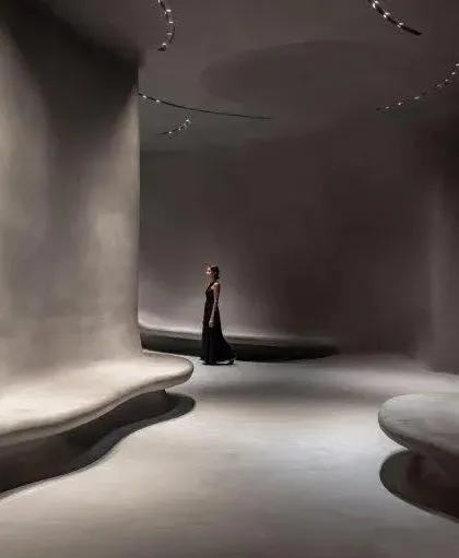 A lone figure in the cavernous, grey-plastered halls of the museum emphasizes the project's focus on introspection and personal journey.
