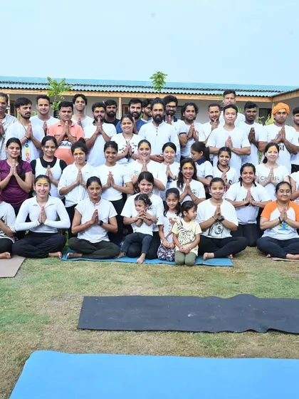 A group photo of our yoga family after a beautiful outdoor practice. The sense of community and shared joy is what makes our school special.