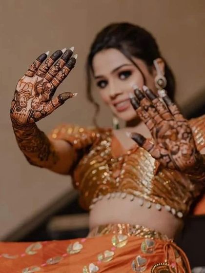 A stunning shot of a bride showing her palms, covered in our signature storytelling mehndi.