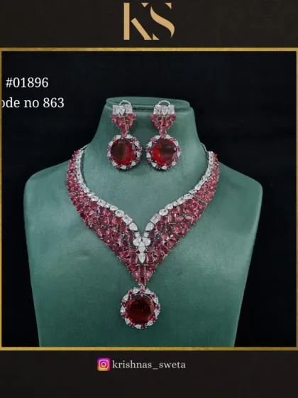 A premium quality American diamond bridal set in a vibrant red. The V-shaped necklace with a large circular pendant is a modern and glamorous design.