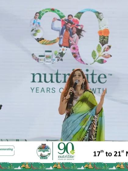 Speaking in front of the '90 Years of Nutrilite' branding at the Amway seminar.
