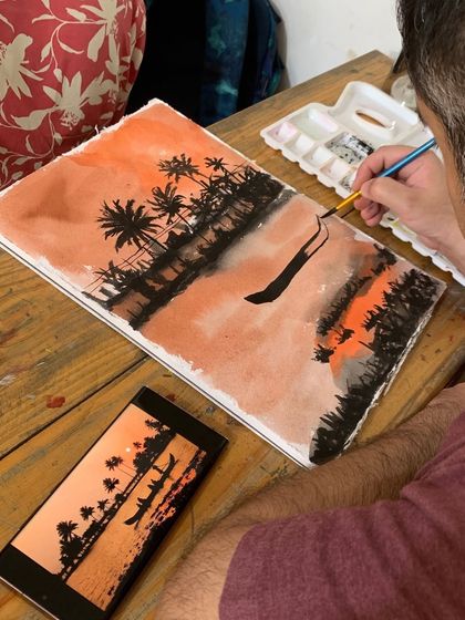 A student creates a dramatic sunset silhouette painting. This exercise teaches control over washes and how to create powerful compositions with a limited color palette.