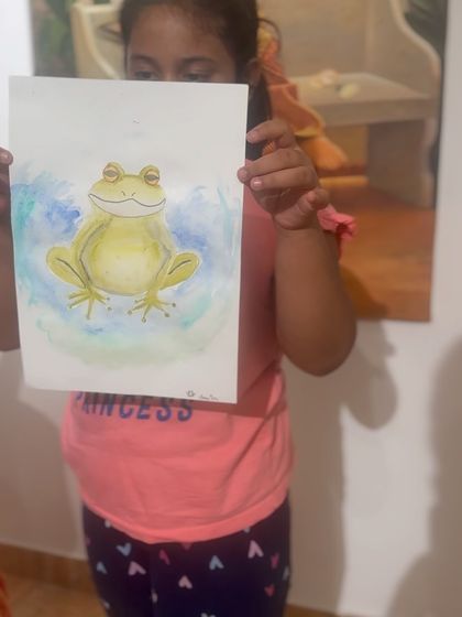 A close-up of a student's frog painting, showing the delicate watercolor washes and fine details.