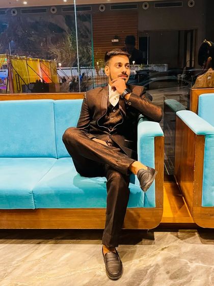 A relaxed, stylish pose from a client at an event. The brown suit is a great choice, and the grooming ensures he looks effortlessly cool.