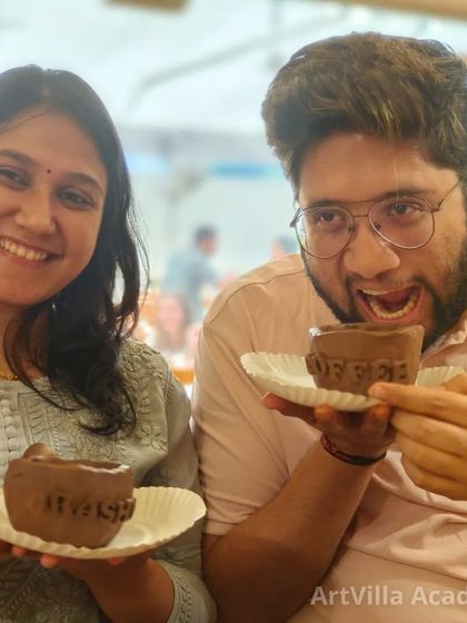 This couple is having a blast showing off the coffee mugs they made for each other at our pottery date workshop. It is a unique and personal way to create a lasting memento.