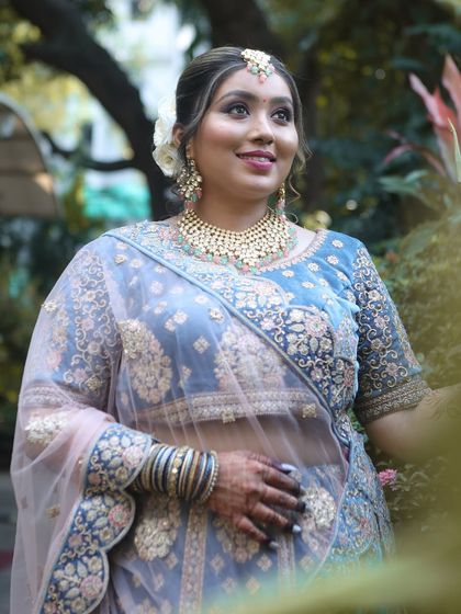 A full-length shot that captures the entire look, from the elegant hairstyle to the detailed embroidery on the lehenga.