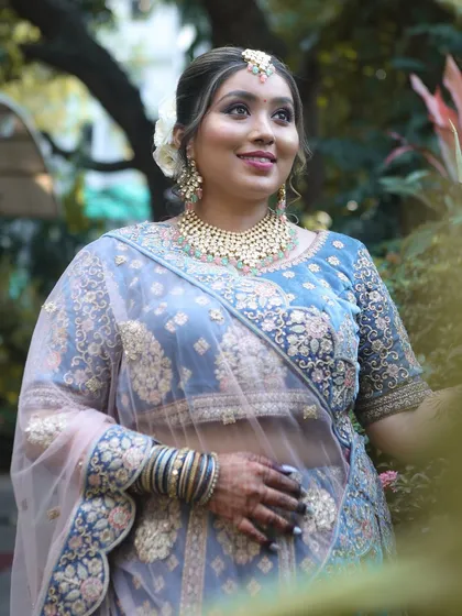 A full-length shot that captures the entire look, from the elegant hairstyle to the detailed embroidery on the lehenga.