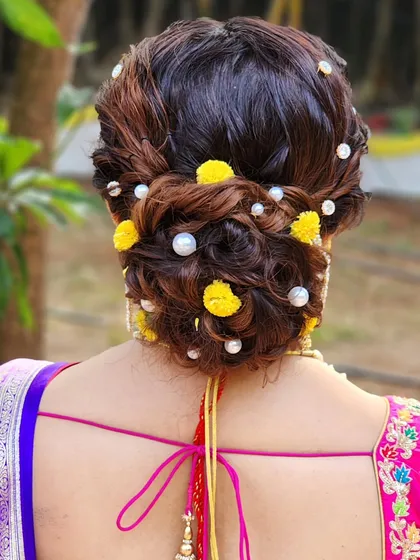 Bridal hair is an art form, and I love creating intricate, textured buns like this one. Adorned with fresh flowers and pearls, this updo is not just a hairstyle but a beautiful accessory that completes the entire bridal look.