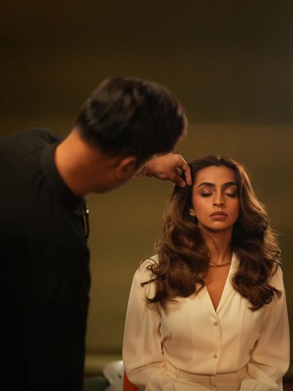 A stylist carefully placing a curl during our campaign shoot. Every detail matters in creating the perfect shot.