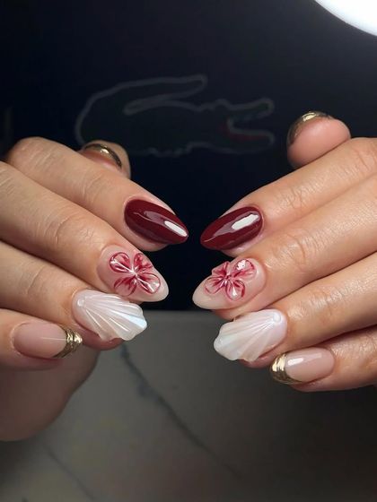 A unique combination of textures and art. This set includes 3D shell textures, a gold-lined French tip, and hand-painted red flowers.