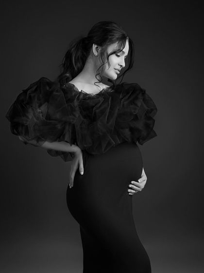 A beautiful and artistic profile shot in black and white, emphasizing the curves of her body and the baby bump.