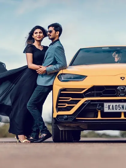 For pre-wedding shoots, we can go for high-impact, glamorous looks. Here, the couple posed with a luxury car, and I created a sophisticated evening look for the bride-to-be with a flowing black gown, soft waves in her hair, and makeup that stood out beautifully against the open landscape.