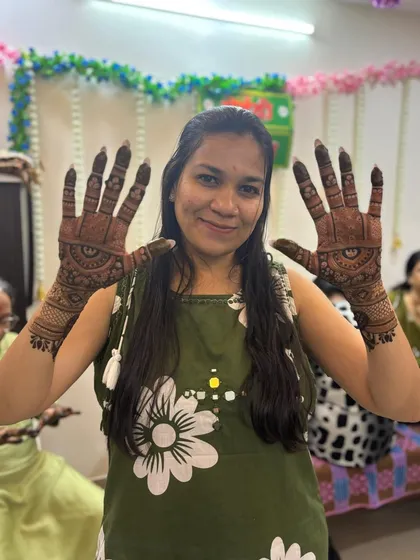 The groom's sister happily showing off her completed party mehendi design.