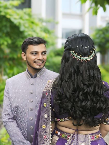 A beautiful couple shot capturing a sweet moment. The bride's personalized hairstyle, featuring her husband's initials, adds a unique and romantic touch to her look.