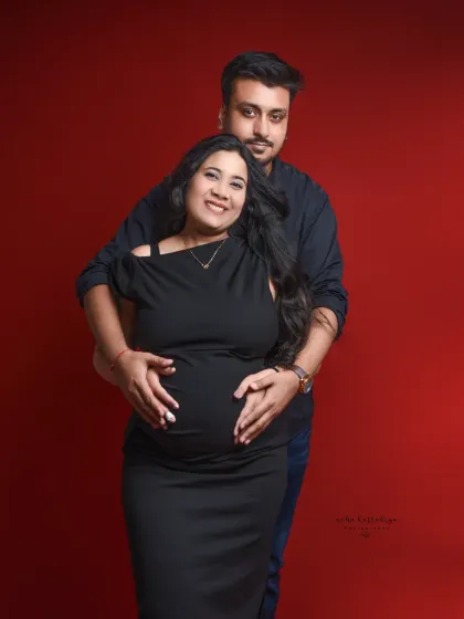 Against a rich red backdrop, this couple's portrait is both bold and intimate. The pose, with the father-to-be embracing the mother from behind, is a wonderful way to frame the baby bump.