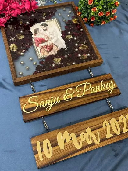 This shot focuses on the two hanging teakwood plaques, personalized with the couple's names and wedding date in gold.