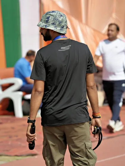 On the track during the Khelo Masters Games, coordinating the event with a microphone in hand. My job is to be on the ground, managing the flow of the competition.