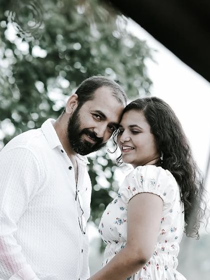 A romantic close-up of a couple, their faces close, framed by natural elements.