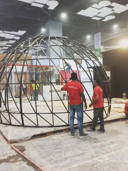 The impressive geodesic dome structure of a booth being assembled on the expo floor.