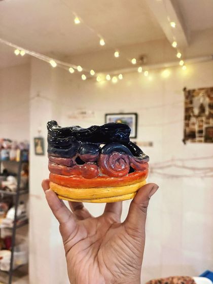 A vibrant, sculptural piece with sunset-colored swirls, created by a beginner student. Her fearless approach to form and color is so inspiring to see.