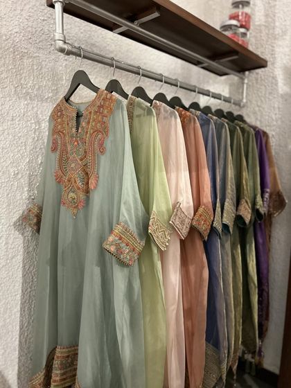 A rack displaying a beautiful spectrum of pastel kurtas, each with its own unique and intricate embroidery.