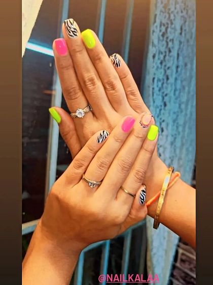 A bold and fun mix-and-match set, combining neon pink and yellow nails with black and white zebra print accent nails.