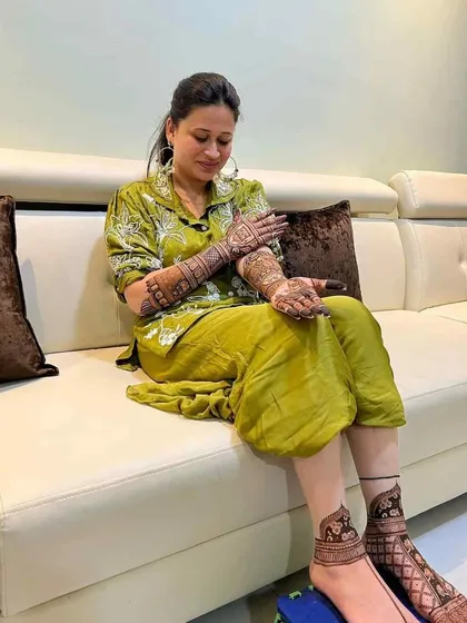 A full shot of a client showing both her hand and feet mehendi designs.