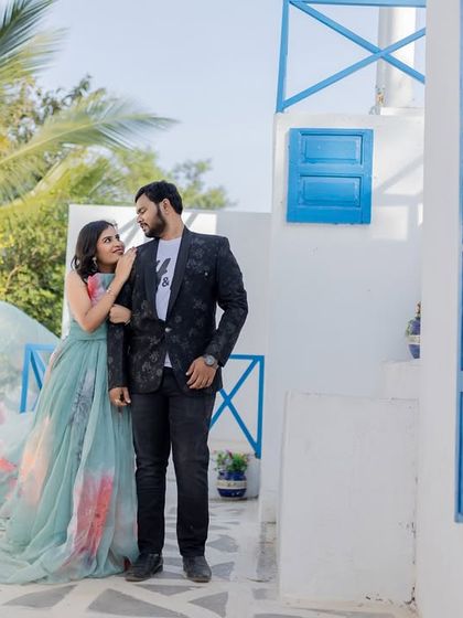 A romantic moment on a balcony set designed to look like a street in Santorini. The white and blue color scheme is perfect for a destination-themed shoot.