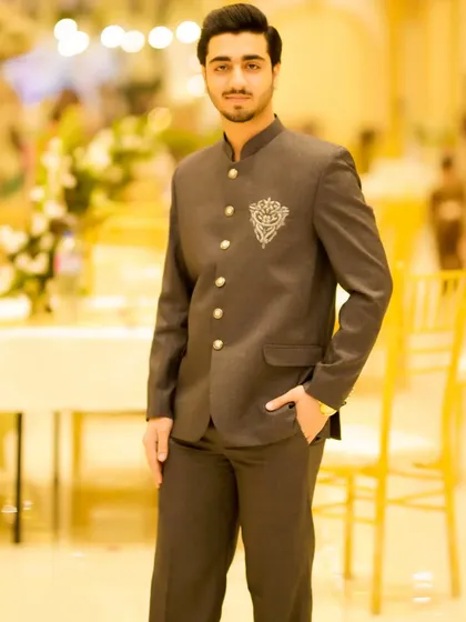 Another angle of this elegant groom's look. The background shows a beautifully decorated wedding venue.