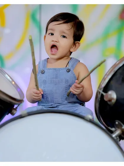 The little drummer boy in action! This colorful shot captures the energy and excitement of a child playing with our drum set prop.