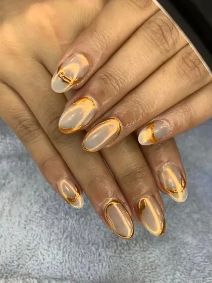 A sophisticated design combining a matte nude base with raised, liquid-gold chrome accents. This look is perfect for someone who wants an artistic and elegant manicure.