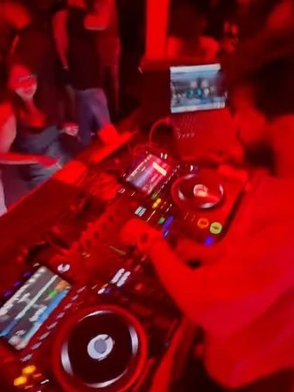 A top-down view of my DJ setup under the red lights of the club. You can see the complexity of the gear I use to create my sound.