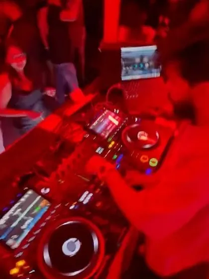 A top-down view of my DJ setup under the red lights of the club. You can see the complexity of the gear I use to create my sound.