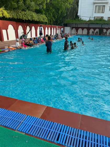 A typical group class at Raj Swimming Academy, with learners of all ages gathered by the poolside. I ensure a structured environment where everyone, from kids to adults, can learn the basics of swimming safely and confidently.