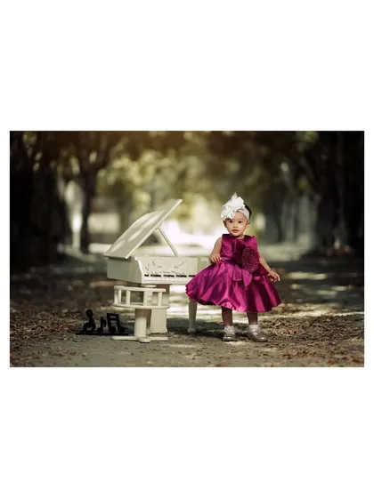 A confident pose from a tiny pianist. Her beautiful dress and the enchanting woodland setting create a truly magical photograph.