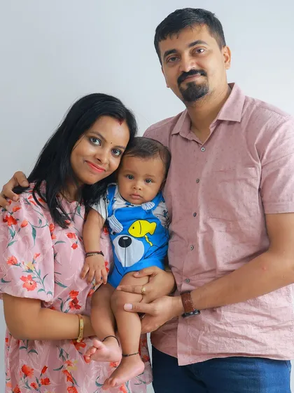 A bright and happy family portrait. This image captures the pride and joy of new parents as they hold their alert and curious little one.