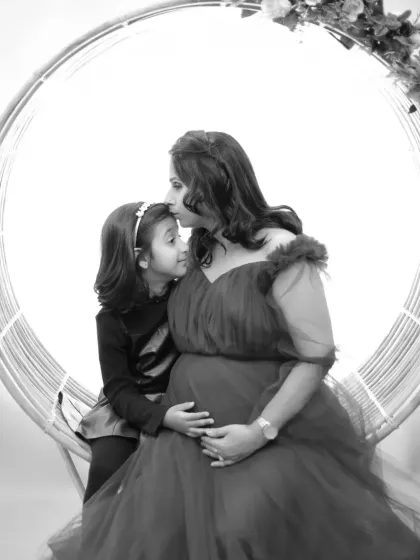 A touching black and white portrait of an expecting mother with her daughter, capturing the anticipation and love of a growing family.