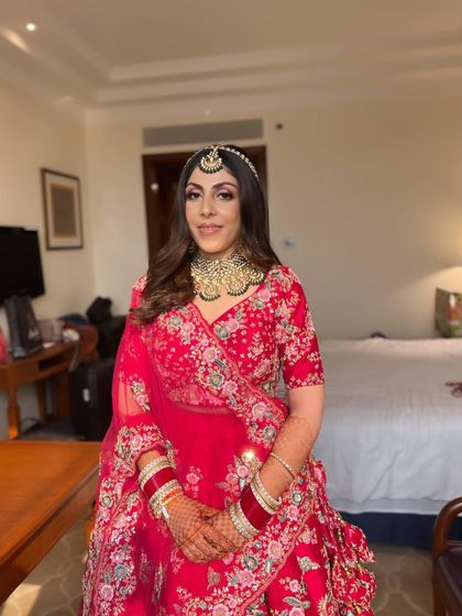 A full shot of Tanya looking radiant and happy in her wedding lehenga, ready to walk down the aisle.