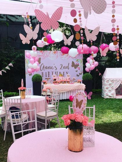 A beautiful butterfly-themed garden party. I used hanging butterfly cutouts, soft pink decor, and a children's play tent to create a whimsical outdoor setting.