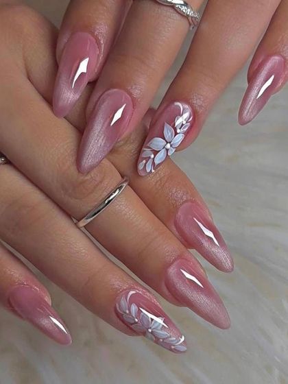For a soft and romantic bridal style, we created these long, pearlescent pink nails. The look is elevated with a single accent nail on each hand, featuring a beautifully hand-painted white floral design.