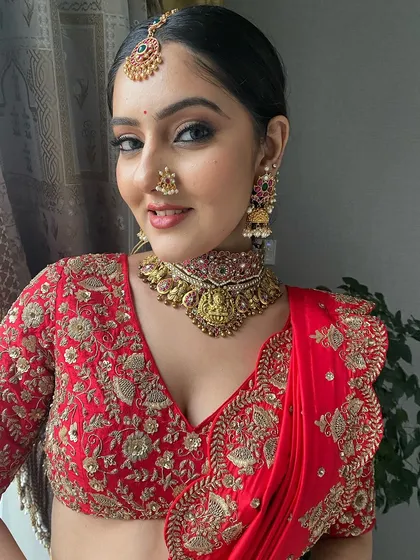 A close-up of this vibrant South Indian bridal look. I focused on creating a flawless complexion, sharp winged eyeliner, and perfectly defined brows to balance the intricate temple jewelry and bold colors of the lehenga.