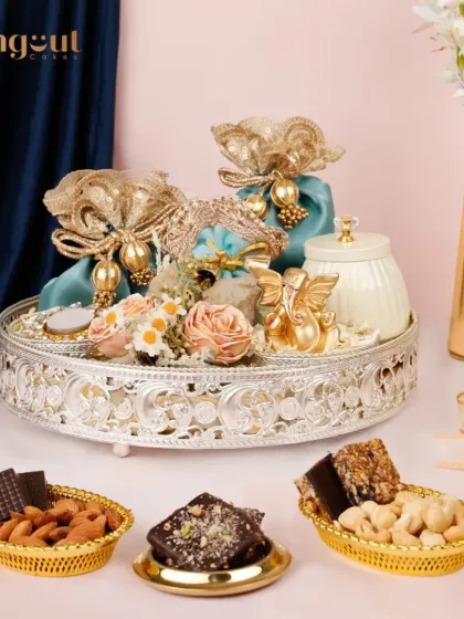 The Ridhya Hamper blends health, taste, and tradition. This festive delight, presented on an ornate silver platter, includes a mix of bliss bars, nuts, and chocolates, making it a perfect gift for any home.
