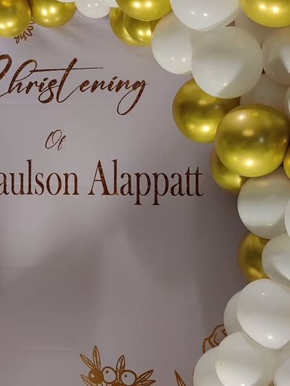 A close-up of the custom backdrop for Jake's Christening, featuring elegant script and a white and gold balloon garland.