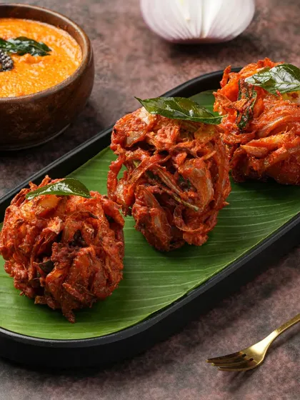 For these crispy Onion Bhajis, we focused on the texture. The styling on a banana leaf with a side of chutney creates a complete, appetizing picture that's perfect for a rainy day promotion.