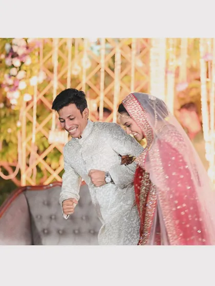 That feeling of pure joy and relief after the formalities are over. This candid shot of the couple's playful energy perfectly captures the fun side of a wedding reception.
