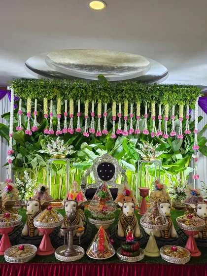 A full view of the stage with the green backdrop and pink floral accents.