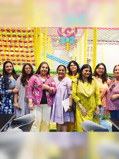 Moms gather and socialize at the Manchester-themed football party, enjoying the celebration while the kids play.