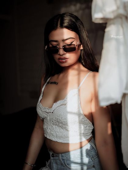 A high-contrast indoor shot using shadows from a window to create a bold, graphic pattern. This technique adds an edgy, fashion-forward look.