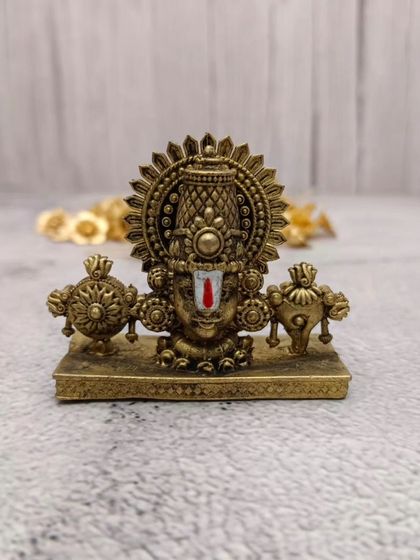 Another angle of the brass Balaji face idol, showing its sturdy base and the intricate work on the crown.