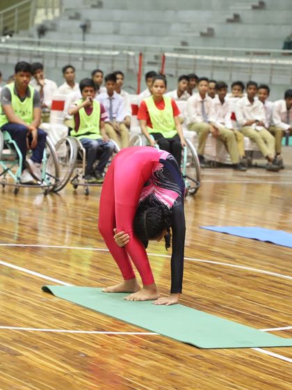 A young gymnast performs an incredible feat of flexibility during our National Sports Day celebration. The event also honored wheelchair basketball medalists, showcasing our commitment to inclusive sports.